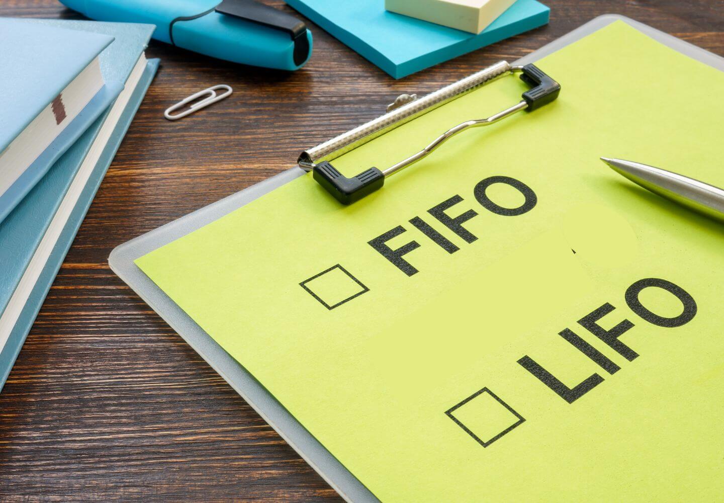 yellow paper on clipboard with "FIFO" and "LIFO" written on it