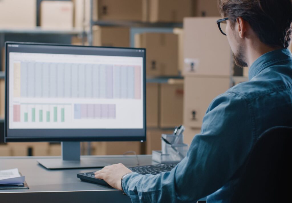 man sitting at computer in warehouse