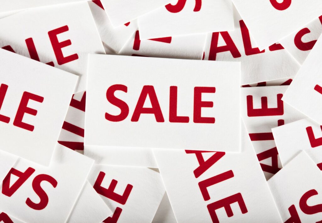 white notecards in a pile with red "SALE" on them