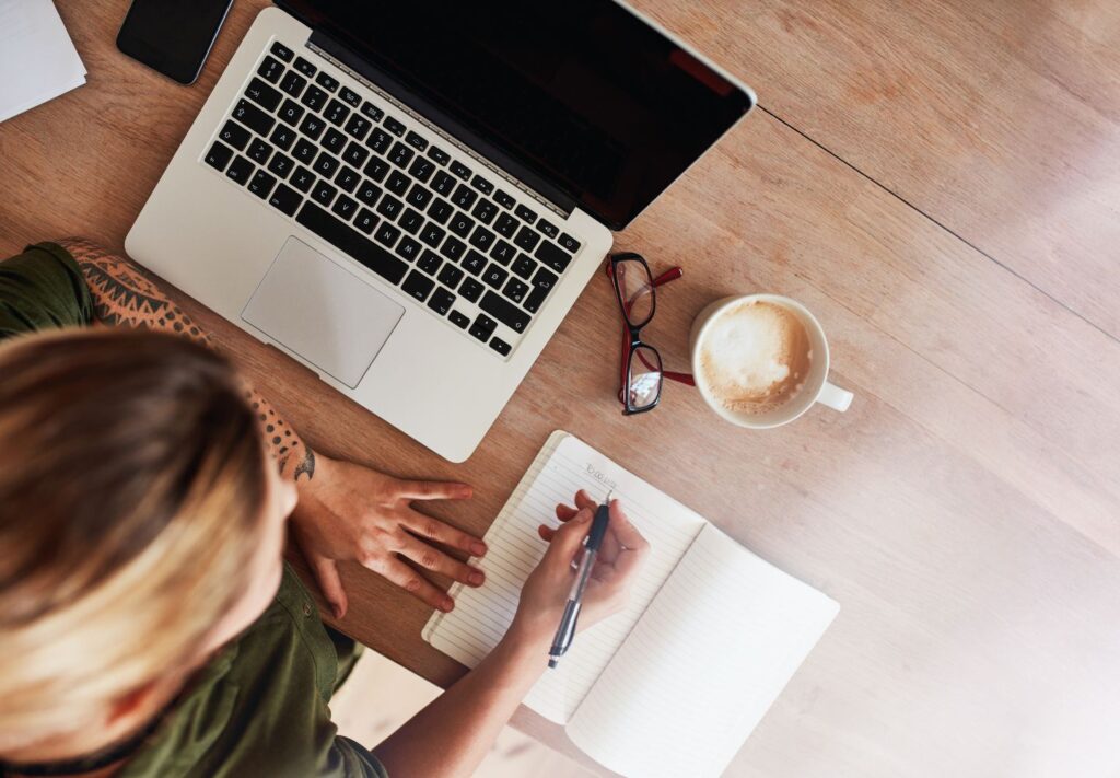 woman at desk writing a to-do list