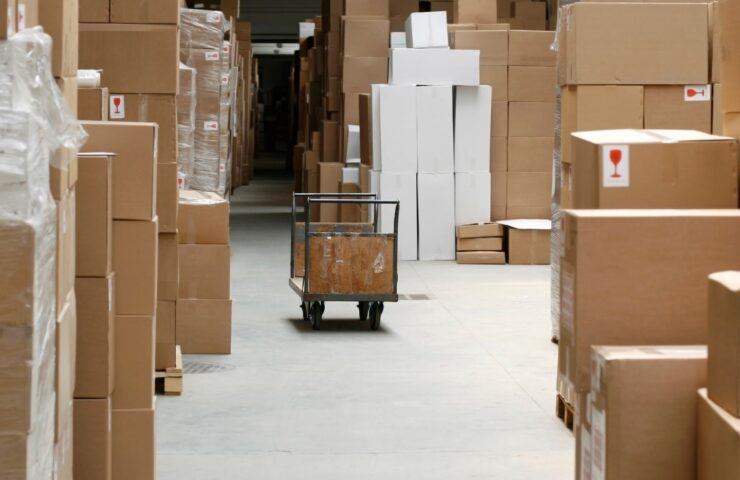 a cart in a warehouse with cardboard boxes